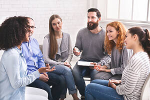Man Psychiatrist Talking With Patients At Rehab Group Meeting