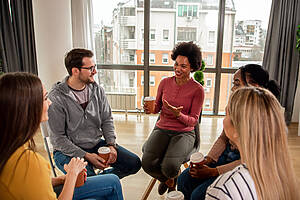 Diverse Group Of People Sitting In Circle In Group Therapy Sessi